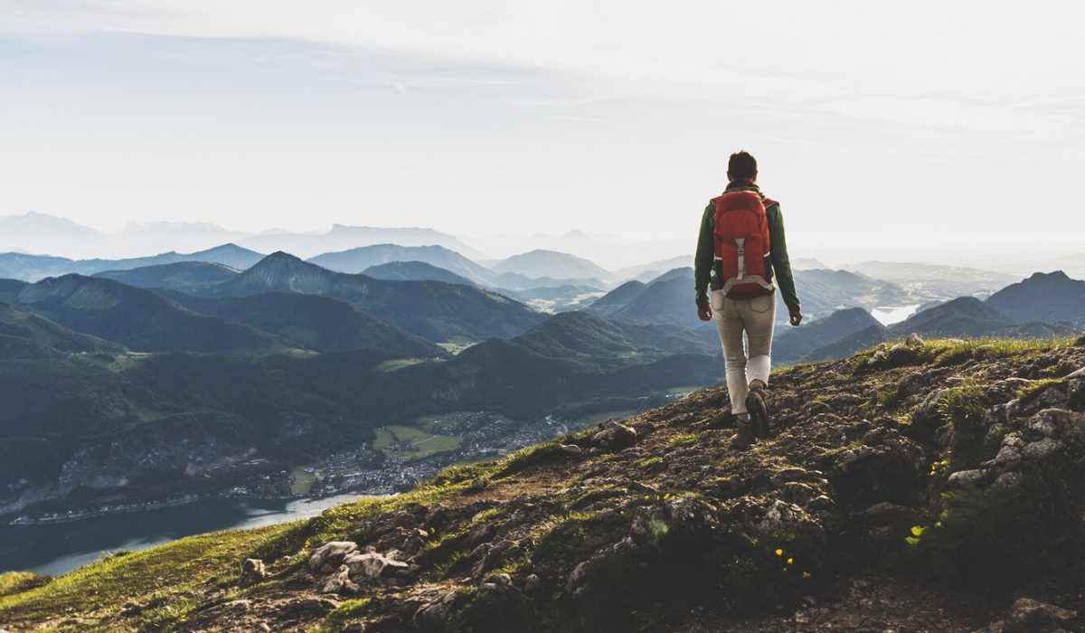 Austria, Salzkammergut, Hiker with backpack hiking in the Alps